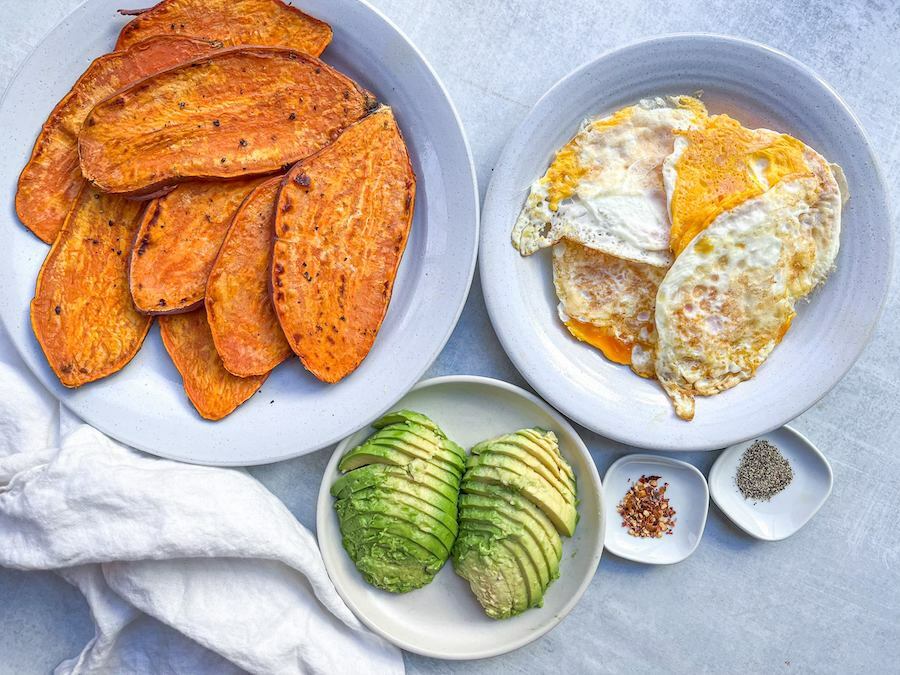 Cooked eggs ready to be assembled with sliced sweet potato and avocado