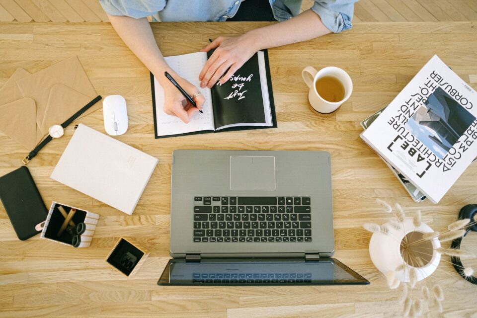 birdseye view of someone taking notes off a computer