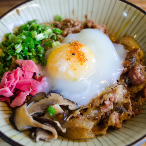 Protein bowl with egg, pickled ginger, mushrooms, bacon, and green onions