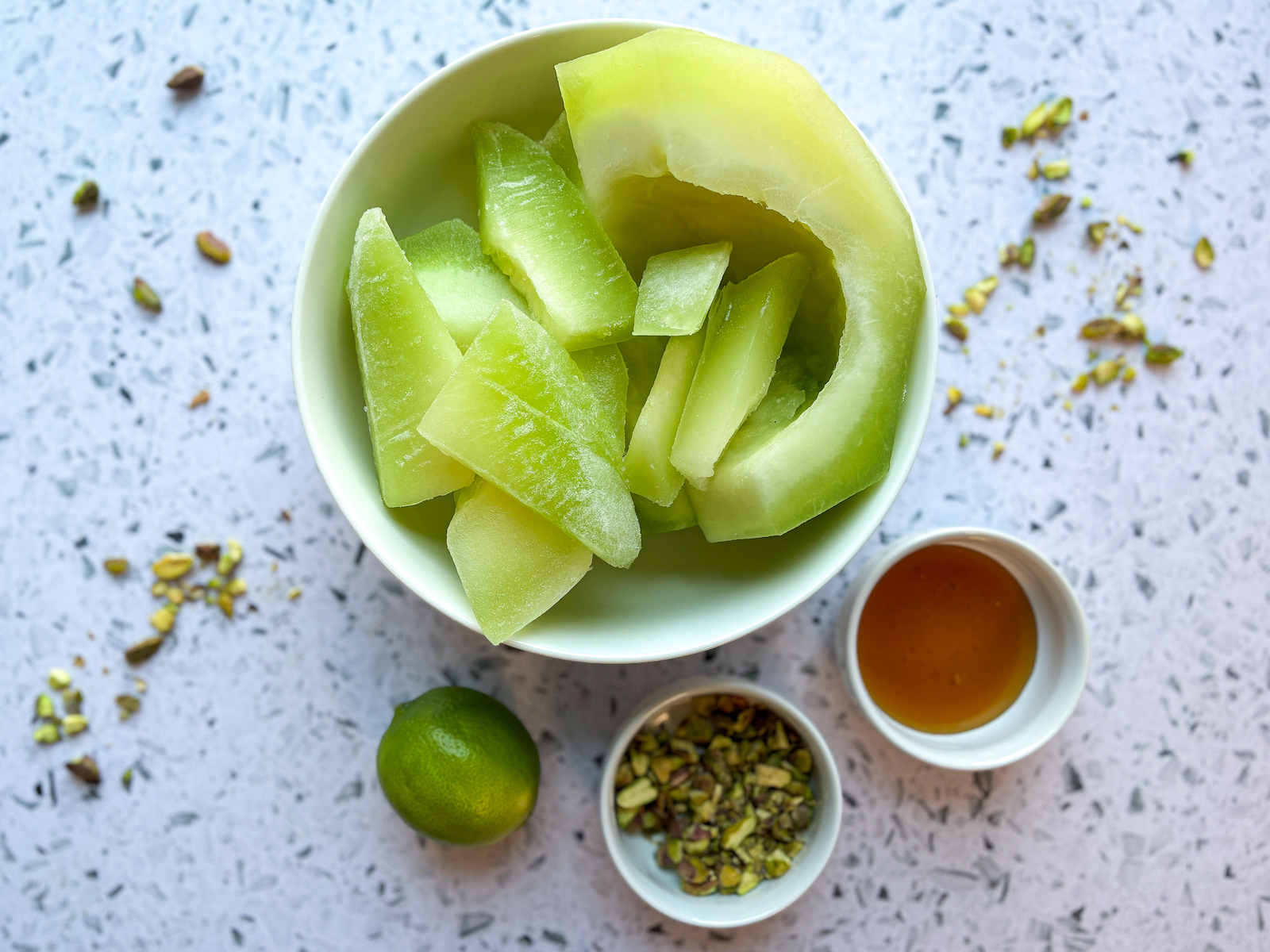 Above photo of Honeydew Granita ingredients, Honeydew Melon, Pistachios, Honey, Lime