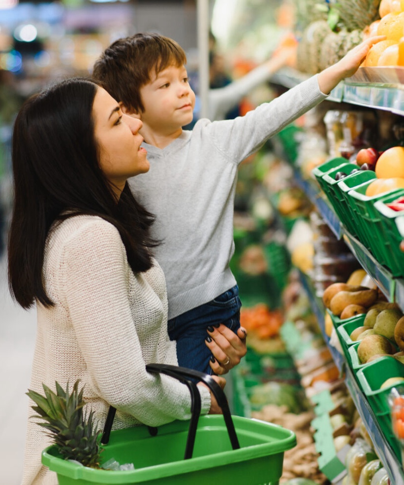 Mother and child shopping at farmer's market for fruits and vegetables