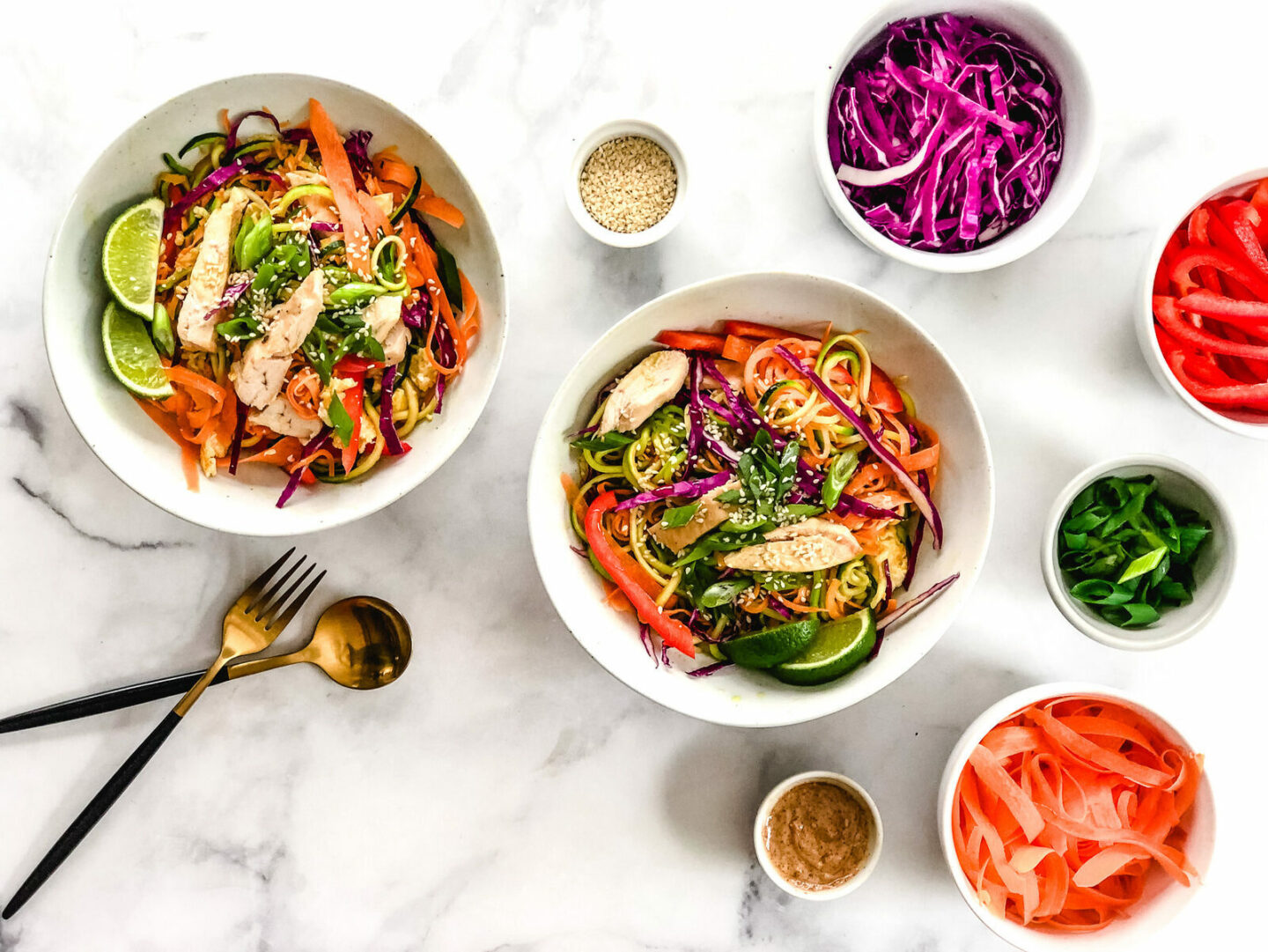 Paleo Pad Thai in two bowls with ingredients surrounding it.