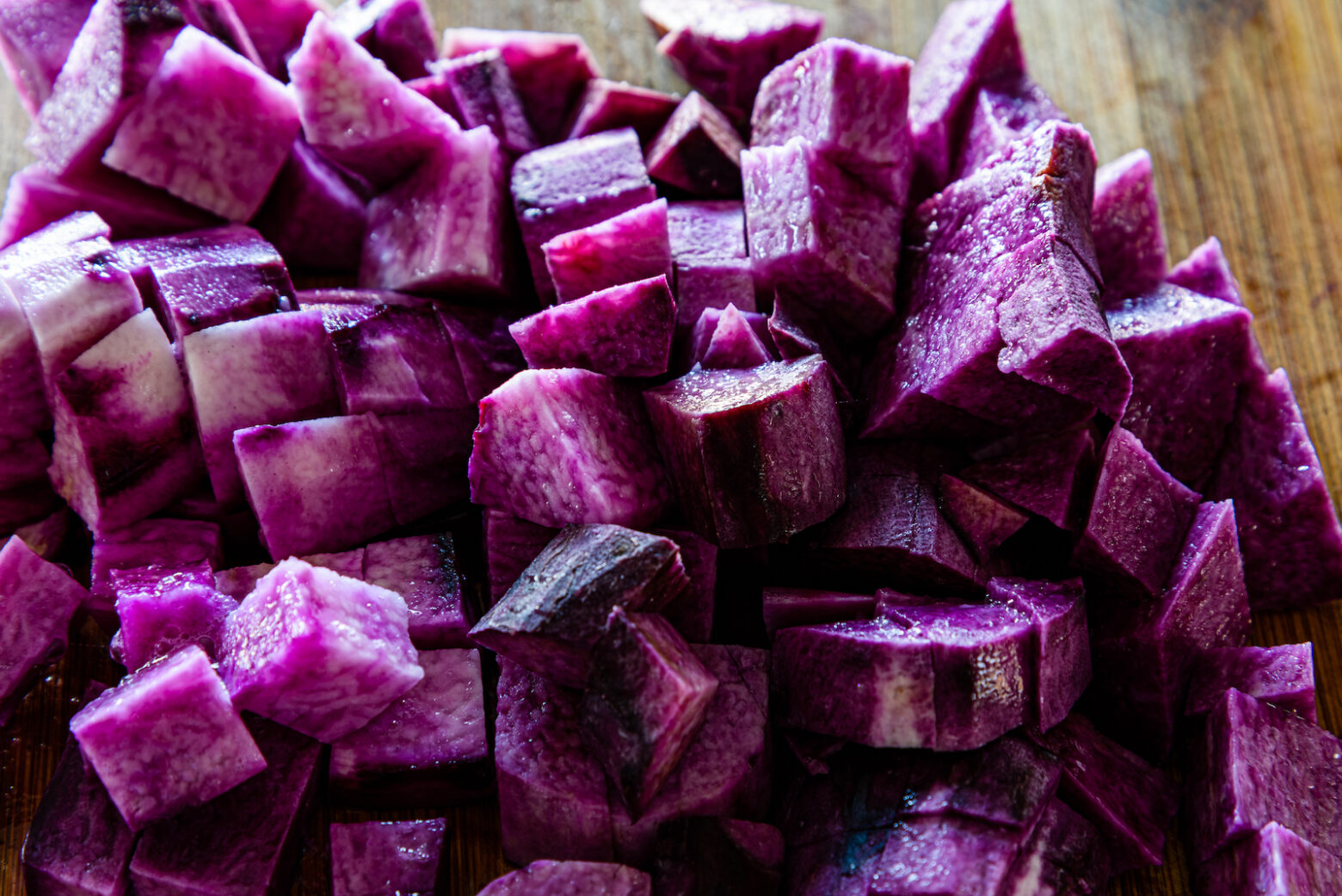 Diced purple yam on a chopping board, close up.