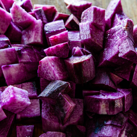 Diced purple yam on a chopping board, close up.