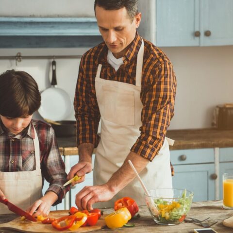 Father and son prepping food in the kitchen.