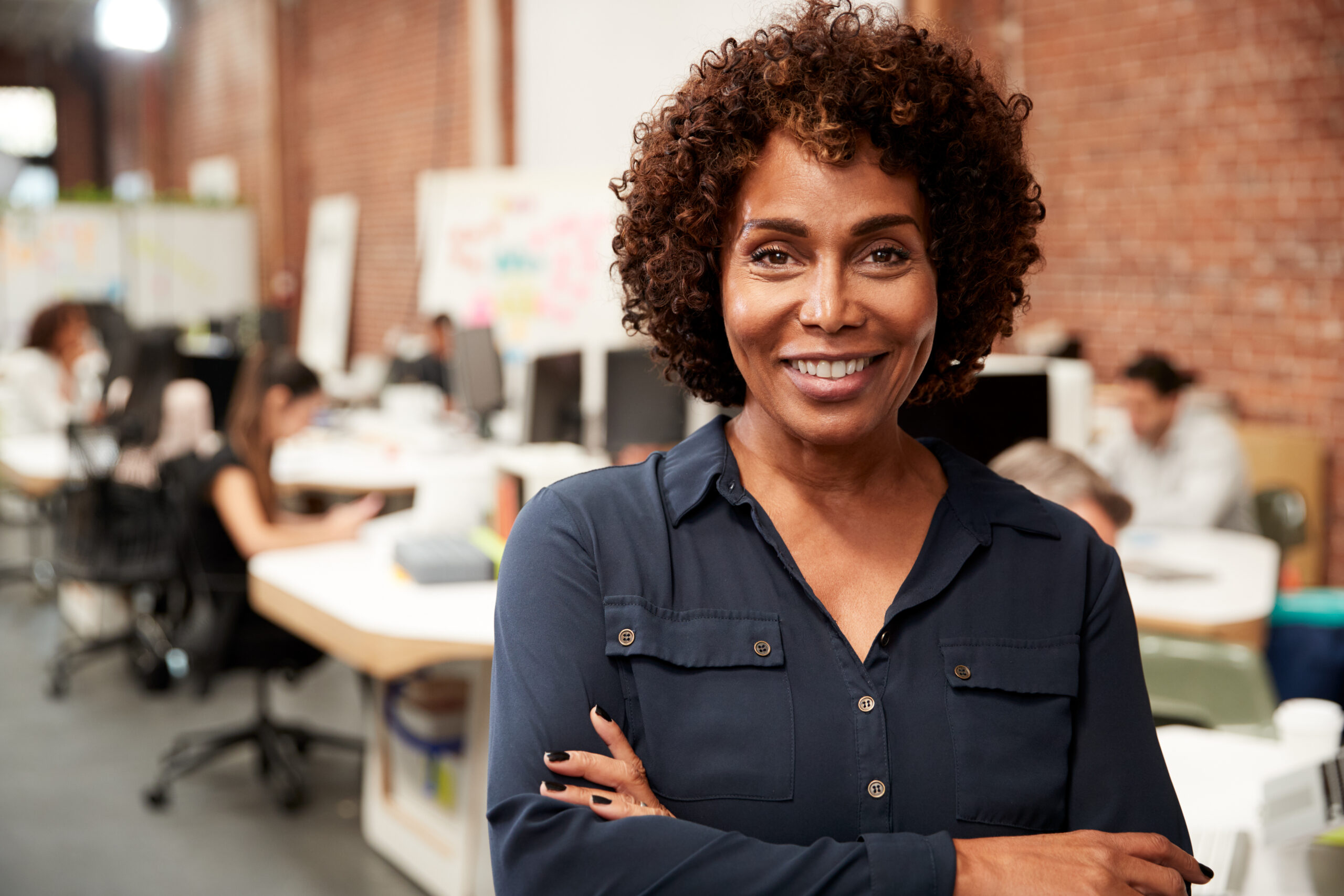 A confident, healthy businesswoman stands in an office