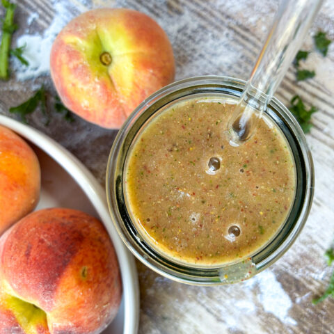 Finished smoothie bird eye view with peaches and kale garnish in the background