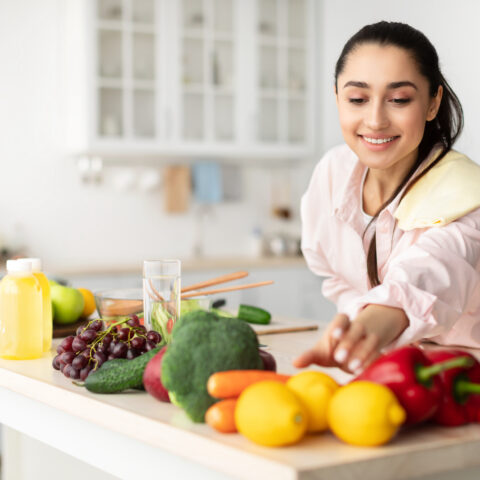 women reaching for vegetables